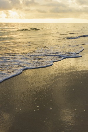 sandy beach and calm blue sea surfの写真素材