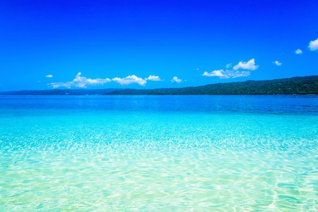 sandy beach and calm blue sea surfの写真素材