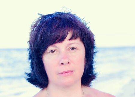 portrait of a middle-aged brunette woman on a background of natureの写真素材