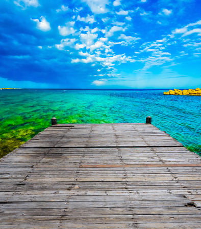 wooden batten bridge juts out into the expanse of the seaの写真素材