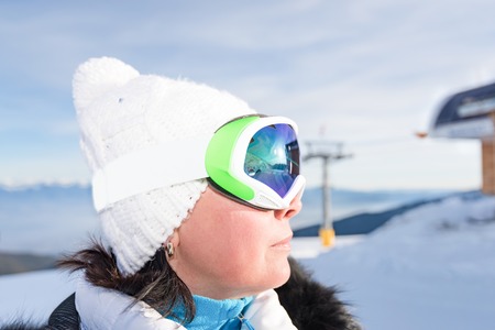 middle-aged woman in a sports suit and skis in the mountainsの写真素材