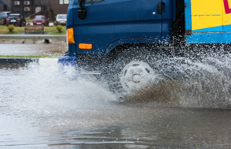 Car rides on big water in the rainの写真素材