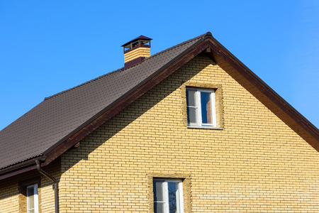 chimney on the roof of the house against the blue skyの写真素材