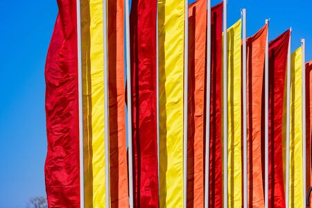 holiday celebration satin flags of different colors in the windの写真素材