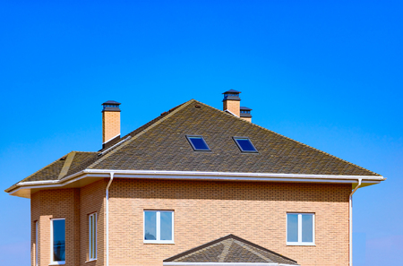 chimney on the roof of the house against the blue skyの写真素材