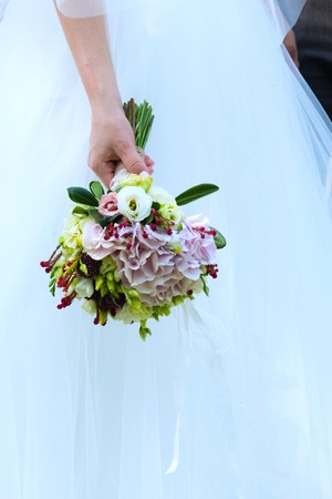 bride in a white dress holding a wedding bouquet of flowersのeditorial素材