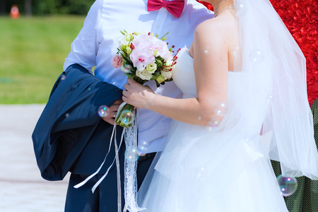 the groom in a blue suit and a bride holding a wedding bouquet of flowersの写真素材
