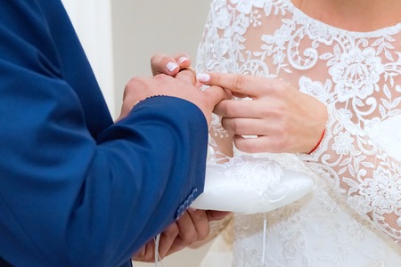bride groom wears a wedding ring on the wedding ceremonyの写真素材