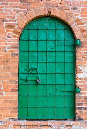 old iron door in the wall of castle masonryの写真素材