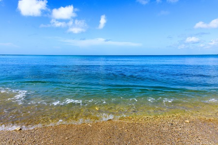 sandy beach and calm blue sea surfの写真素材