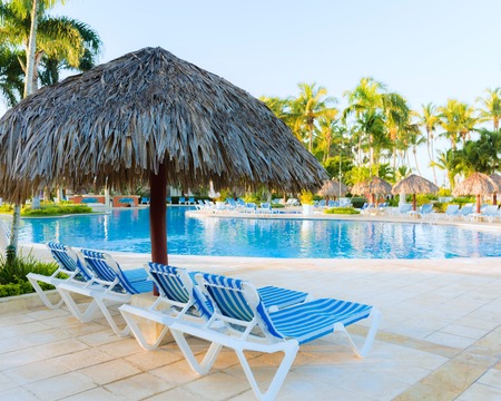 deck chairs under a canopy stand near the swimming poolの写真素材