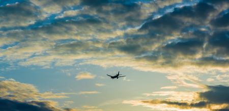 aircraft flying in the sky storm clouds sunsetの写真素材