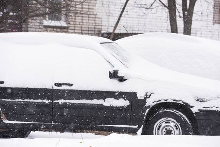 car is parked tunes with a thick layer of snow blizzard cold winterの写真素材