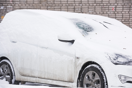 car is parked tunes with a thick layer of snow blizzard cold winterの写真素材