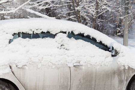 car is parked tunes with a thick layer of snow blizzard cold winterの写真素材