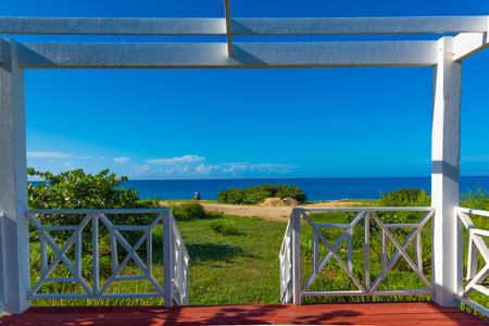 wooden white gazebo on the beach view green grassの写真素材