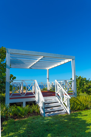 wooden white gazebo on the beach view green grassの写真素材