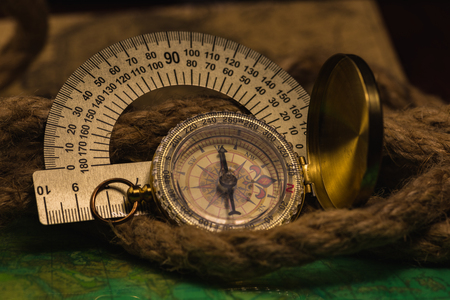 The compass and protractor lies on an old cardの写真素材