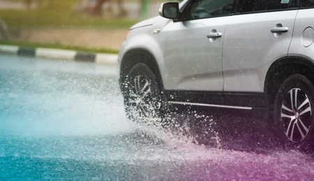 motion car rain big puddle of water spray from the wheelsの写真素材