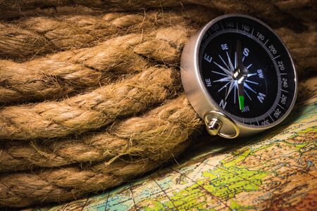 Vintage compass with a rope on an old mapの写真素材