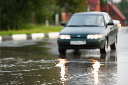 Motion blur car rides on a wet road in the rainの写真素材