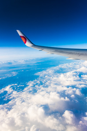 Looking out the window at the airplane wing sky skyline cloudsの写真素材