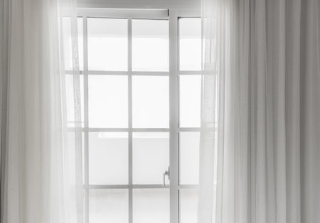 white large window the door on the balcony is closed with a lumen of a curtainの写真素材
