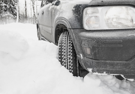 car wheel in deep winter snow snowbank wheel protectorの写真素材