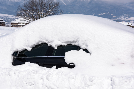 car is parked tunes with a thick layer of snow blizzard cold winterの写真素材