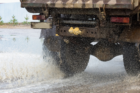 motion car rain big puddle of water spray from the wheelsの写真素材