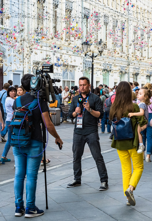 MOSCOW, JUNE , 2018. The reporter makes a reportage on the street. The period of the International FIFA World Cup 2018 in Russiaのeditorial素材