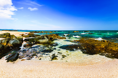 coastline of the sea rocky coastline against the blue sky with a cloudの写真素材
