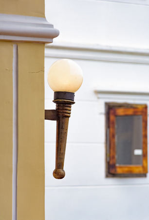 Glass ball on a wooden handle retro street lamp hanging on the wallの写真素材