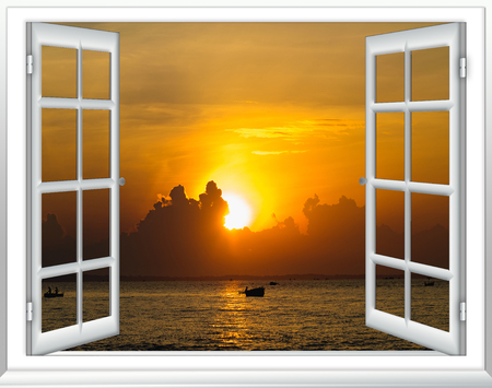 Beautiful sunset on the sea view from the window with curtains openの写真素材