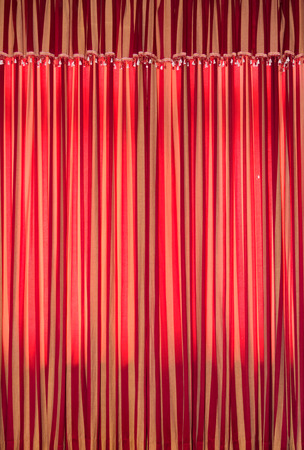 Dense textile red curtain background with foldsの写真素材