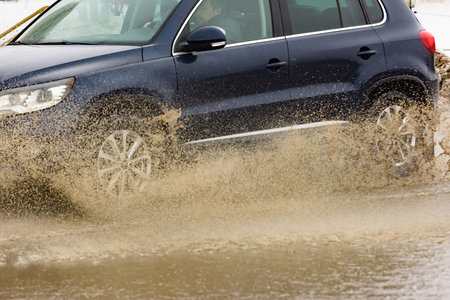 Russia. Moscow. 15 - March 2019. A car drives through a pool of water with splashes. Spring flood in...