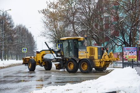 Russia. Chekhov. February 16, 2019.Tractor loads snow into the truck. City services snow removal special equipment after snowfall. urban utilitiesのeditorial素材