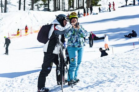 Bulgaria. Bansko. 12 February 2019.Bansko ski station, Kolarski ski lift at Banderishka polyana, skiers on ski slopes, mountain. With pine trees, people. Snowのeditorial素材