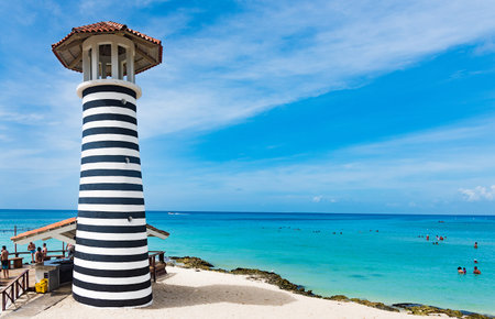La Romana, Dominican Republic. 10 October 2019. striped high lighthouse stands on the shores of the Caribbean Dominican Republic for the safety of ships. Hotel Beach Barのeditorial素材