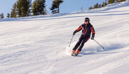 Bulgaria. Bansko. 10 February 2020.  Skier riding down the huge snowfield splashing powder snow.のeditorial素材