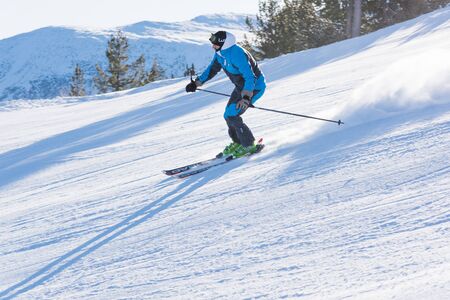 Bulgaria. Bansko. 10 February 2020.  Skier riding down the huge snowfield splashing powder snow.のeditorial素材