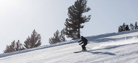 Bulgaria. Bansko. 10 February 2020.  Skier riding down the huge snowfield splashing powder snow.のeditorial素材