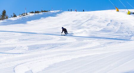 Bulgaria. Bansko. 10 February 2020.  Skier riding down the huge snowfield splashing powder snow.のeditorial素材