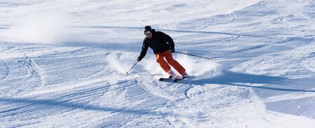 Bulgaria. Bansko. 10 February 2020.  Skier riding down the huge snowfield splashing powder snow.のeditorial素材
