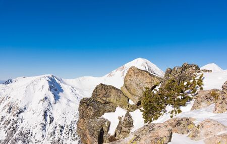 Mountain top in snow against a cloudy sky in winterの写真素材