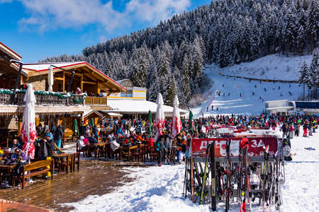 Bansko, Bulgaria - February 14, 2020: Winter ski resort Bansko, ski slope, people skiing and mountains view.のeditorial素材