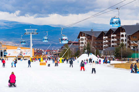 Bansko, Bulgaria - February 14, 2020: Winter ski resort Bansko, ski slope, people skiing and mountains view.のeditorial素材