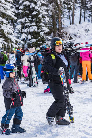 Bansko, Bulgaria - February 14, 2020: Winter ski resort Bansko, ski slope, people skiing and mountains view.のeditorial素材