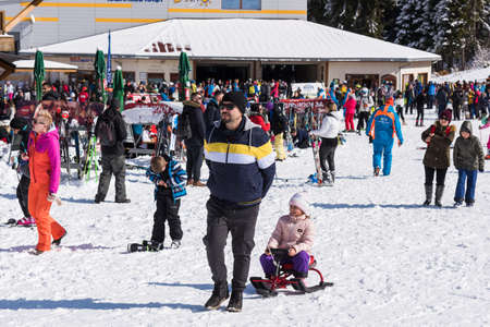Bansko, Bulgaria - February 14, 2020: Winter ski resort Bansko, ski slope, people skiing and mountains view.のeditorial素材