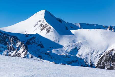 mountain peaks covered with snow illuminated by a bright sunの写真素材